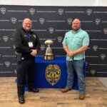 Chief Tucker and Major Moore pose with Mississippi football memorabilia in Oxford Chief Tucker and Major Moore pose with Mississippi football memorabilia in Oxford